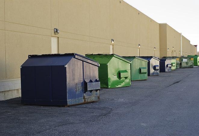 tilted front-load dumpsters being emptied by waste management workers in Ama LA